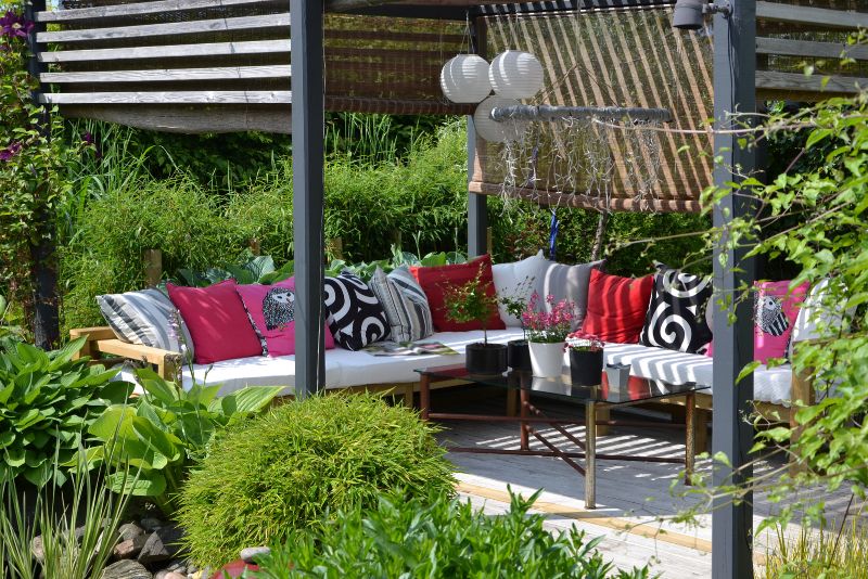Outdoor lounge area under a pergola with cushioned seating
